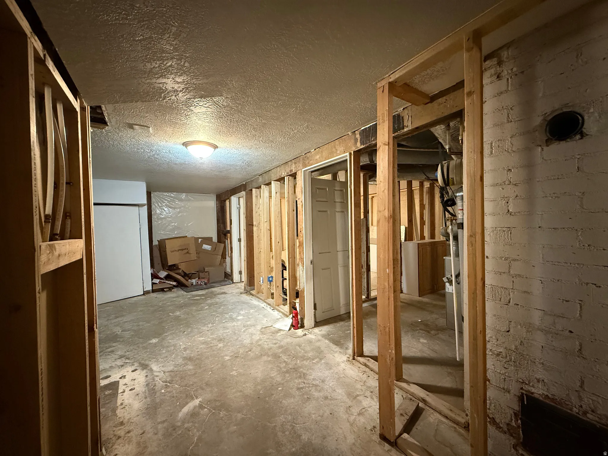 Miscellaneous room featuring unfinished concrete floors and a textured ceiling