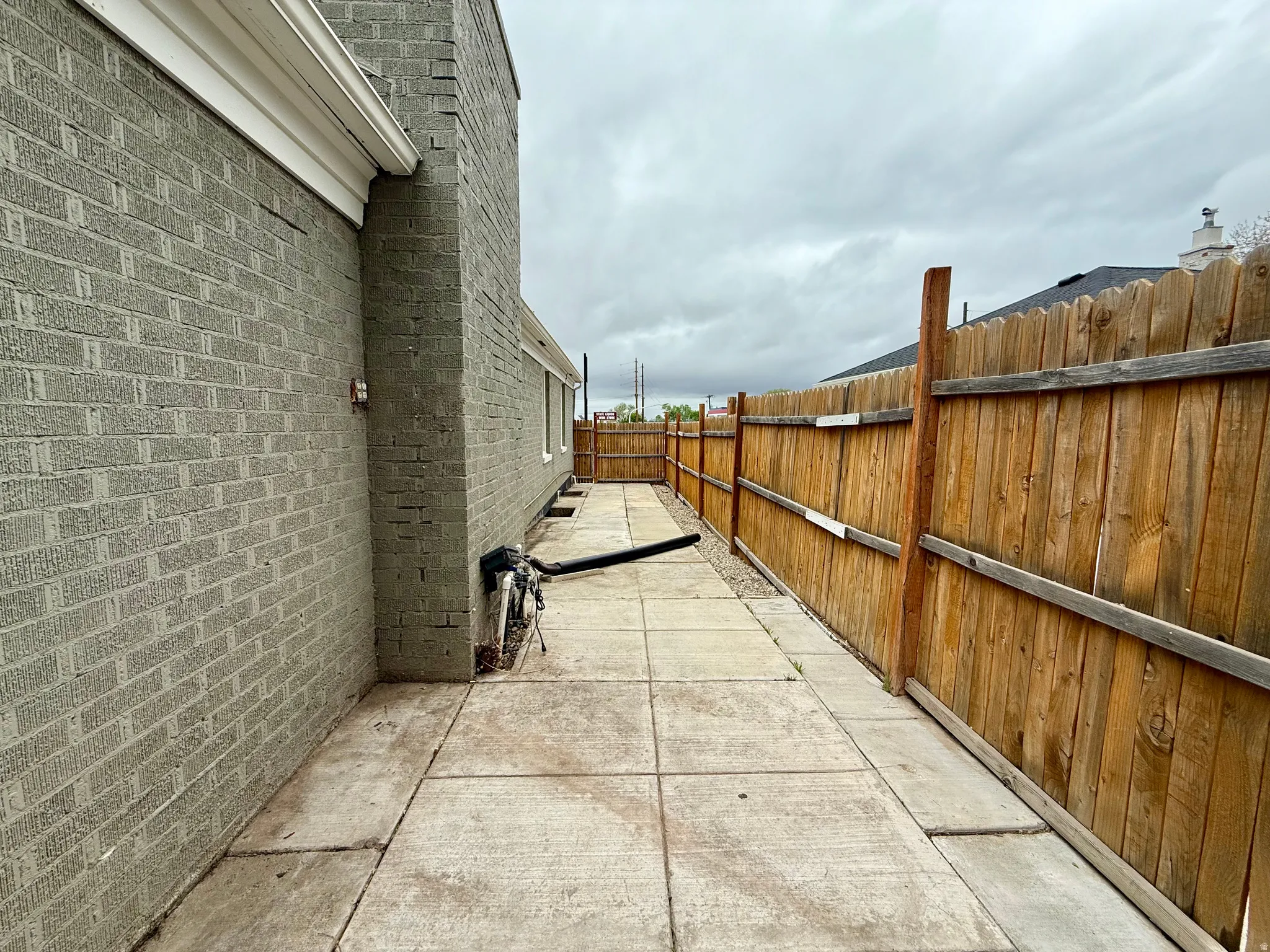 Fenced backyard featuring north side of house