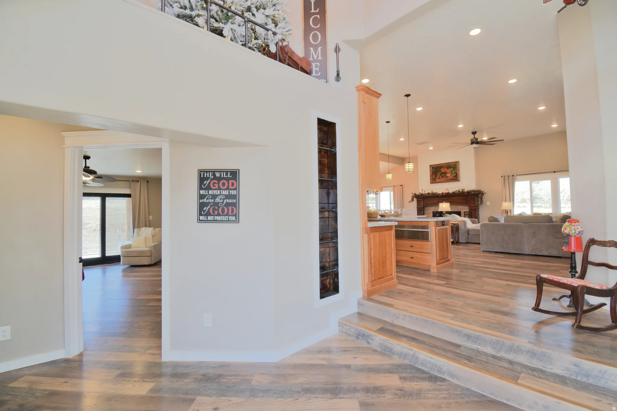 Living room with ceiling fan, recessed lighting, a fireplace, light wood-style floors, and healthy amount of natural light. Featuring built in ladder leading to "reading nook".