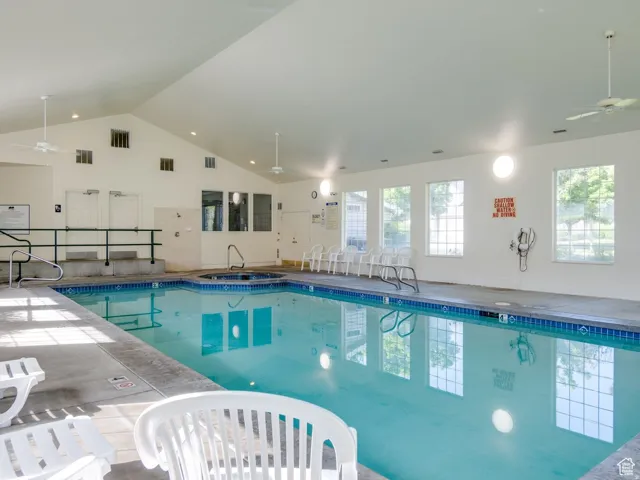 Indoor community pool featuring ceiling fan and a sink