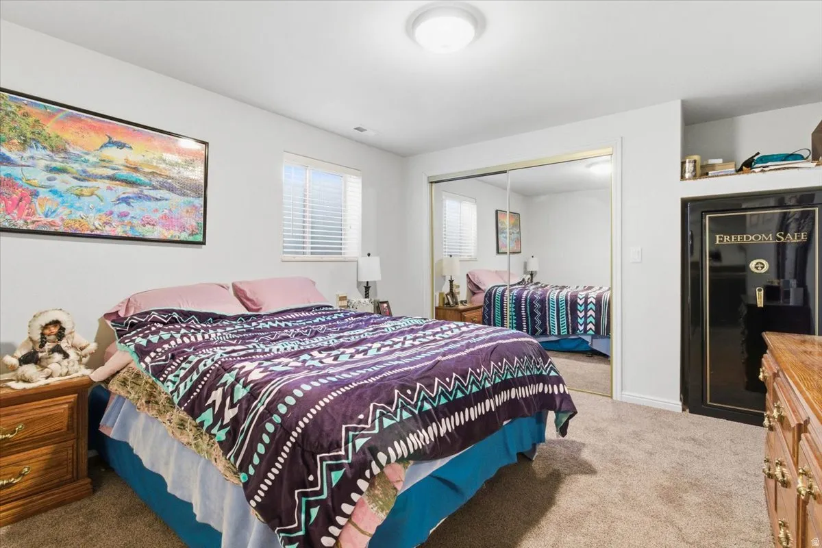 Bedroom featuring light carpet and a closet