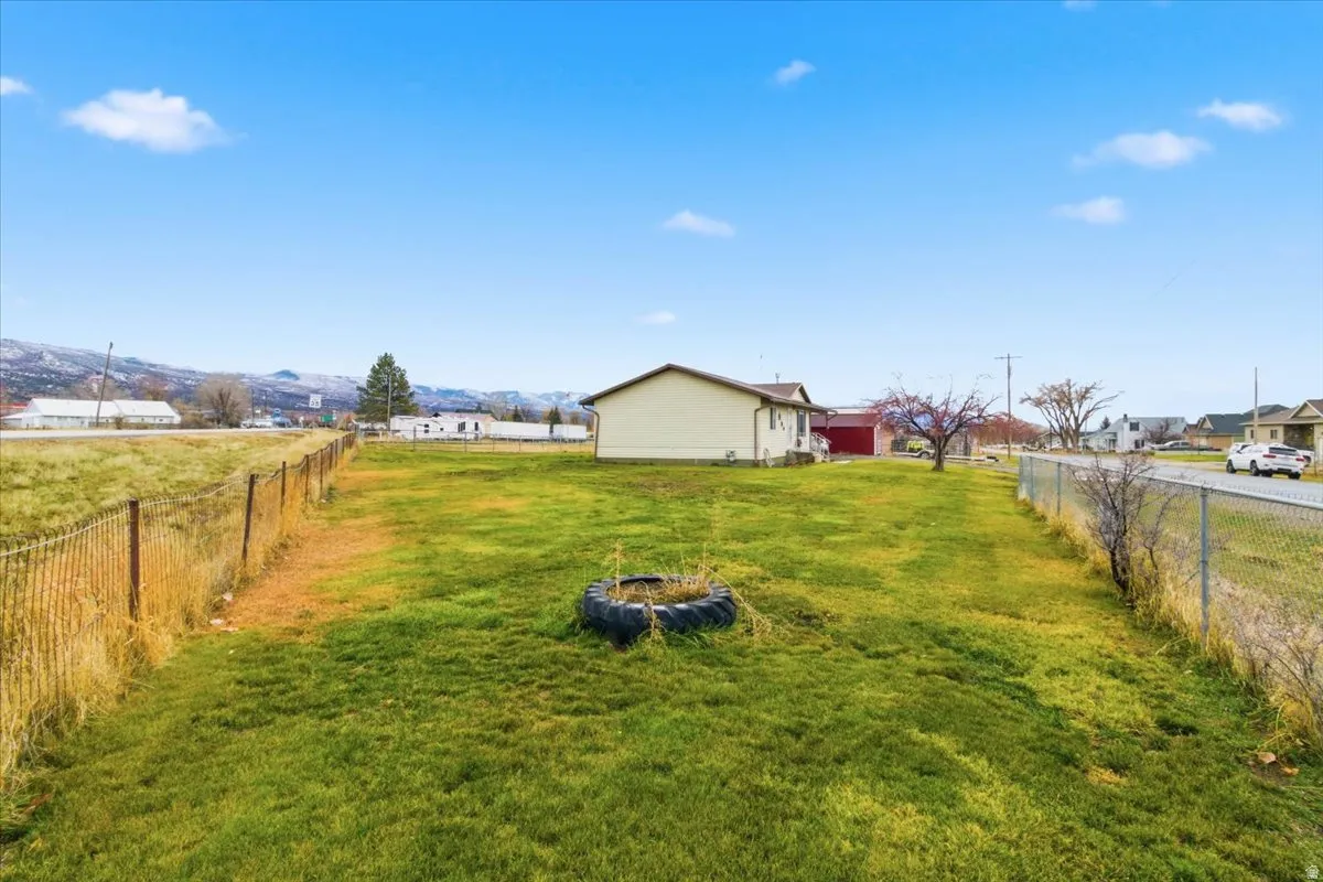 Fenced backyard featuring a rural view and an outdoor fire pit