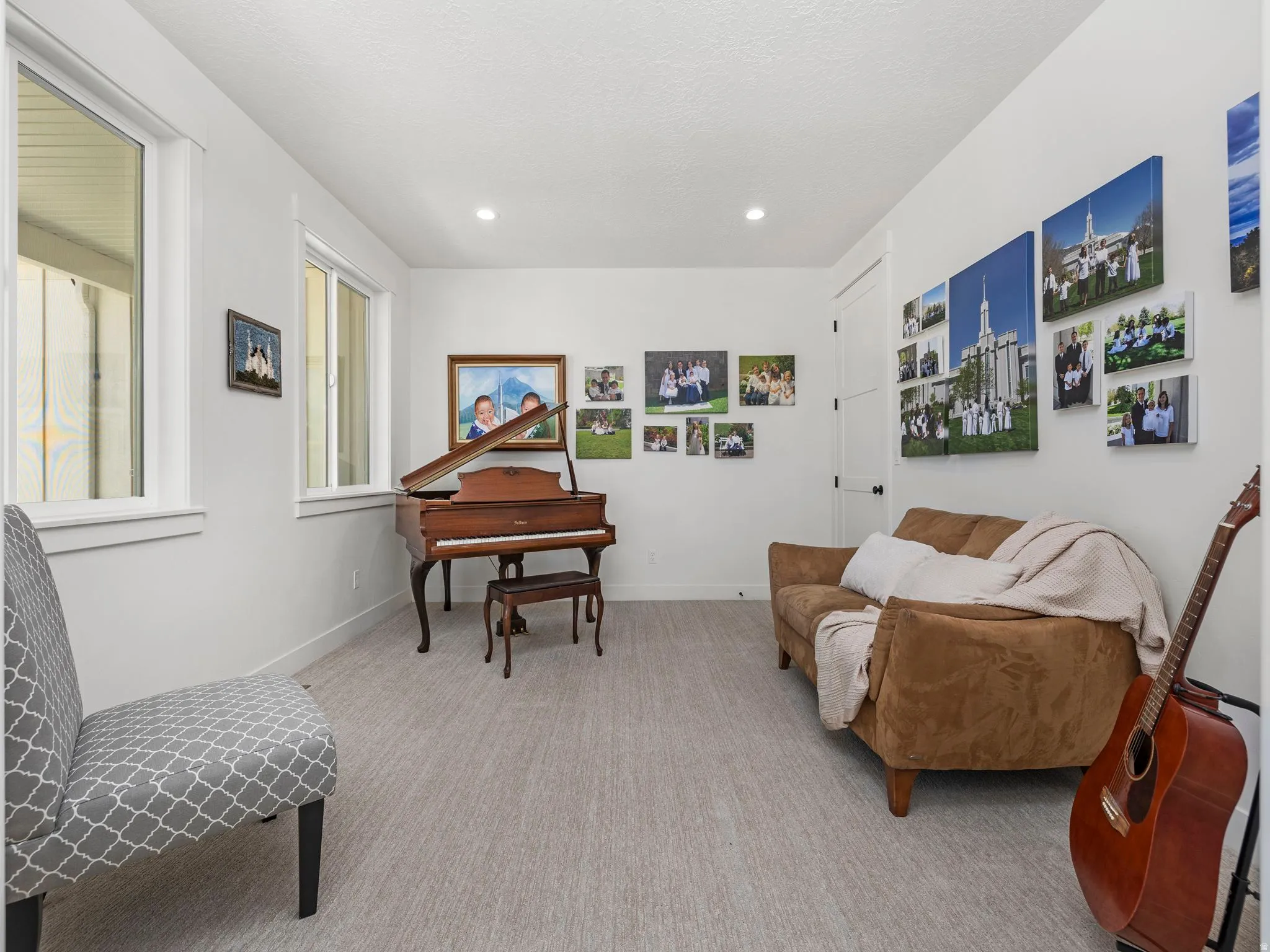 Sitting room right off of the front entry, with light colored carpet and recessed lighting