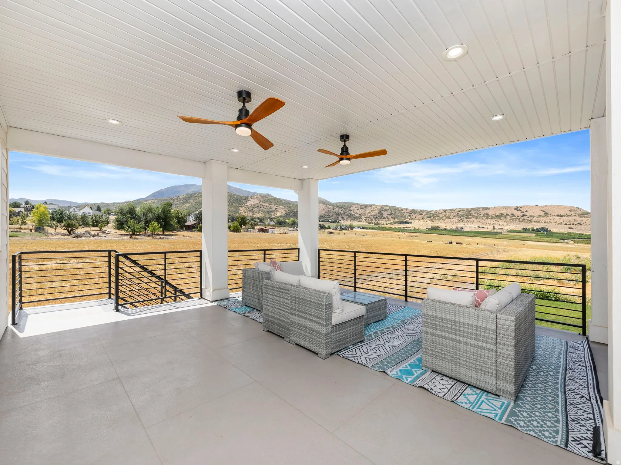 Upstairs covered deck right off of the HUGE loft. Featuring a mountain view, a ceiling fan, a view of rural / pastoral area, and outdoor lounge area