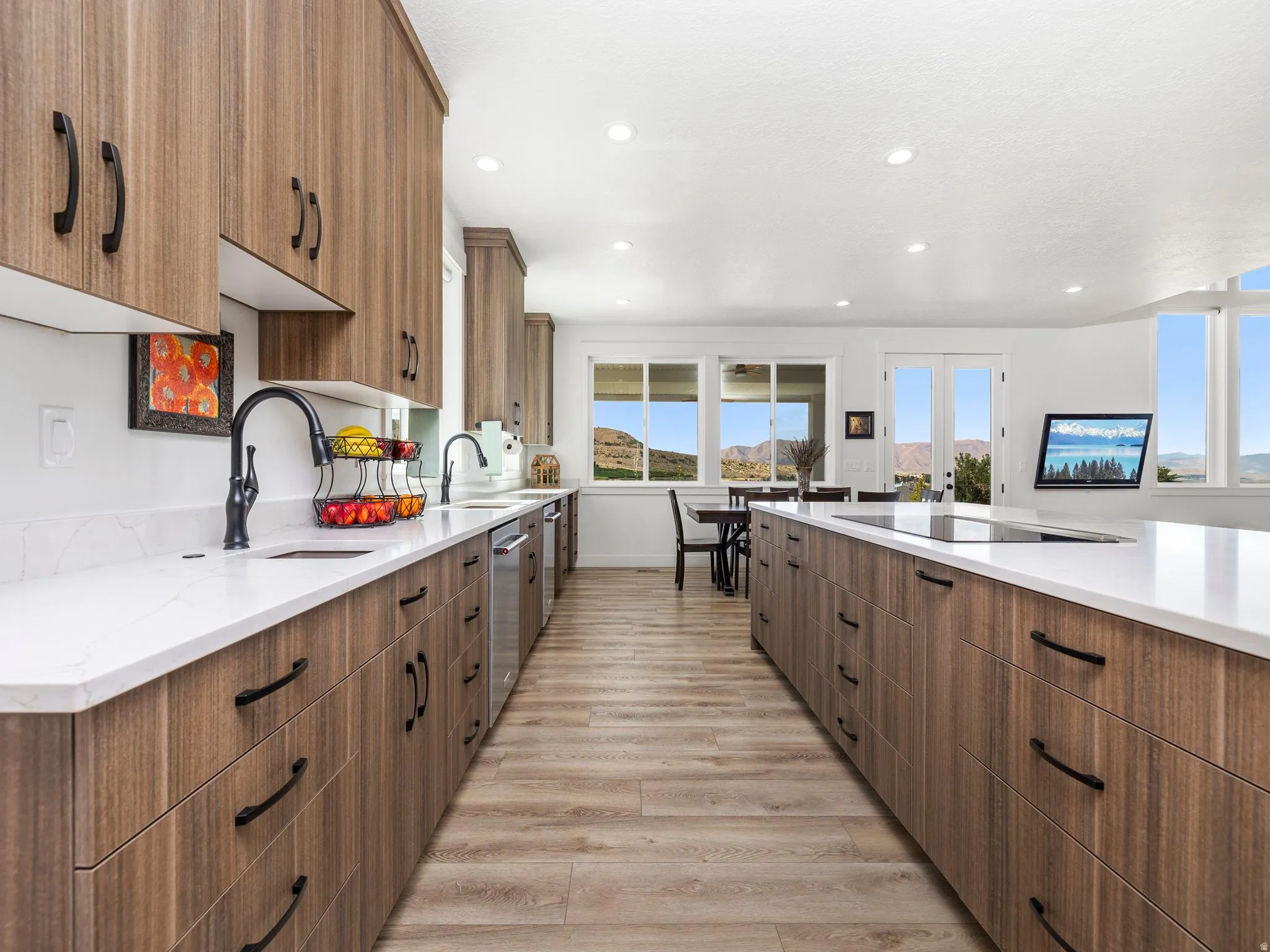 Kitchen featuring brown cabinets, light stone counters, light wood-style flooring, recessed lighting, and black electric stovetop