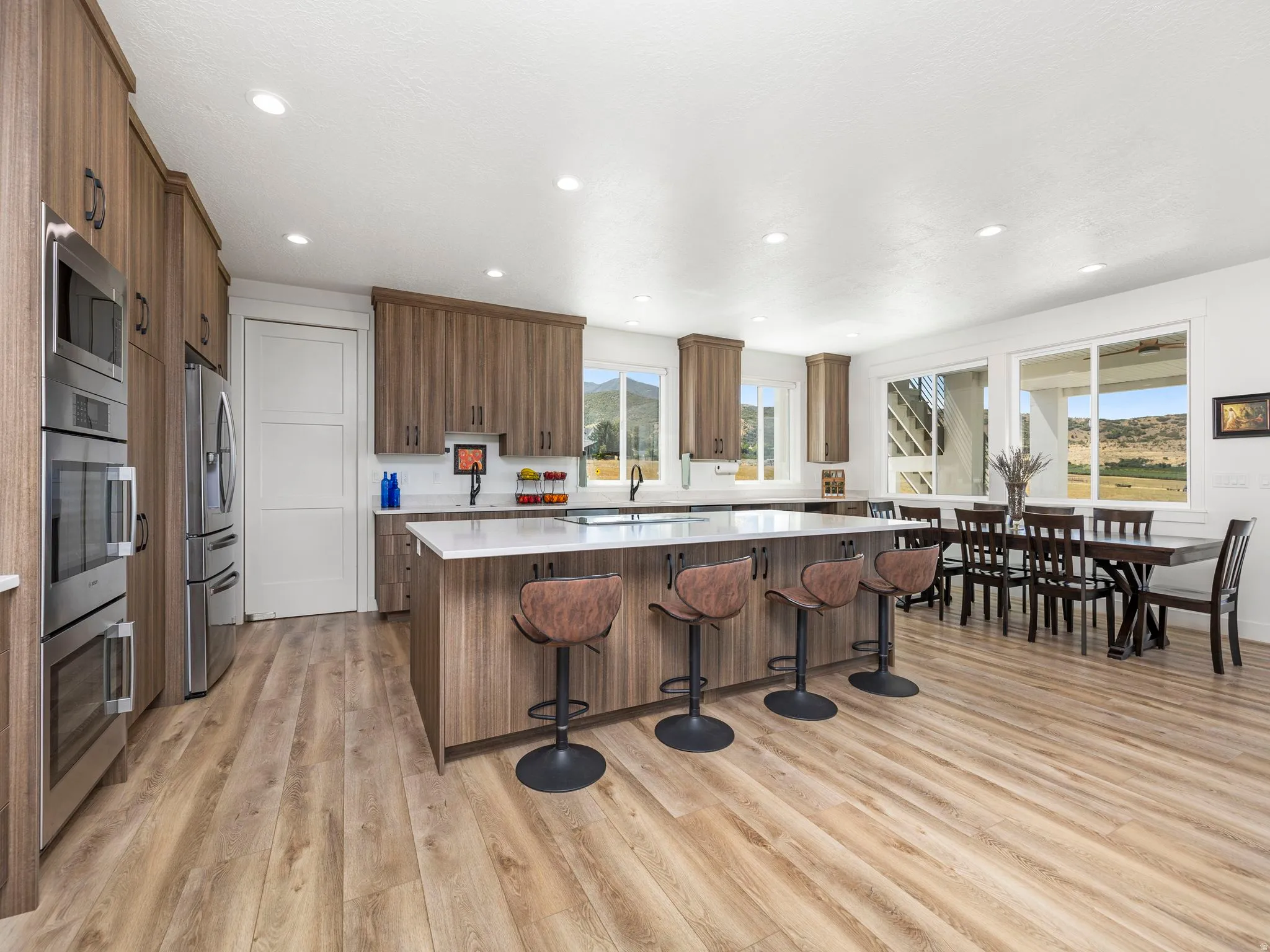 Kitchen with a center island, a kitchen breakfast bar, stainless steel appliances, light wood-style floors, and brown cabinets
