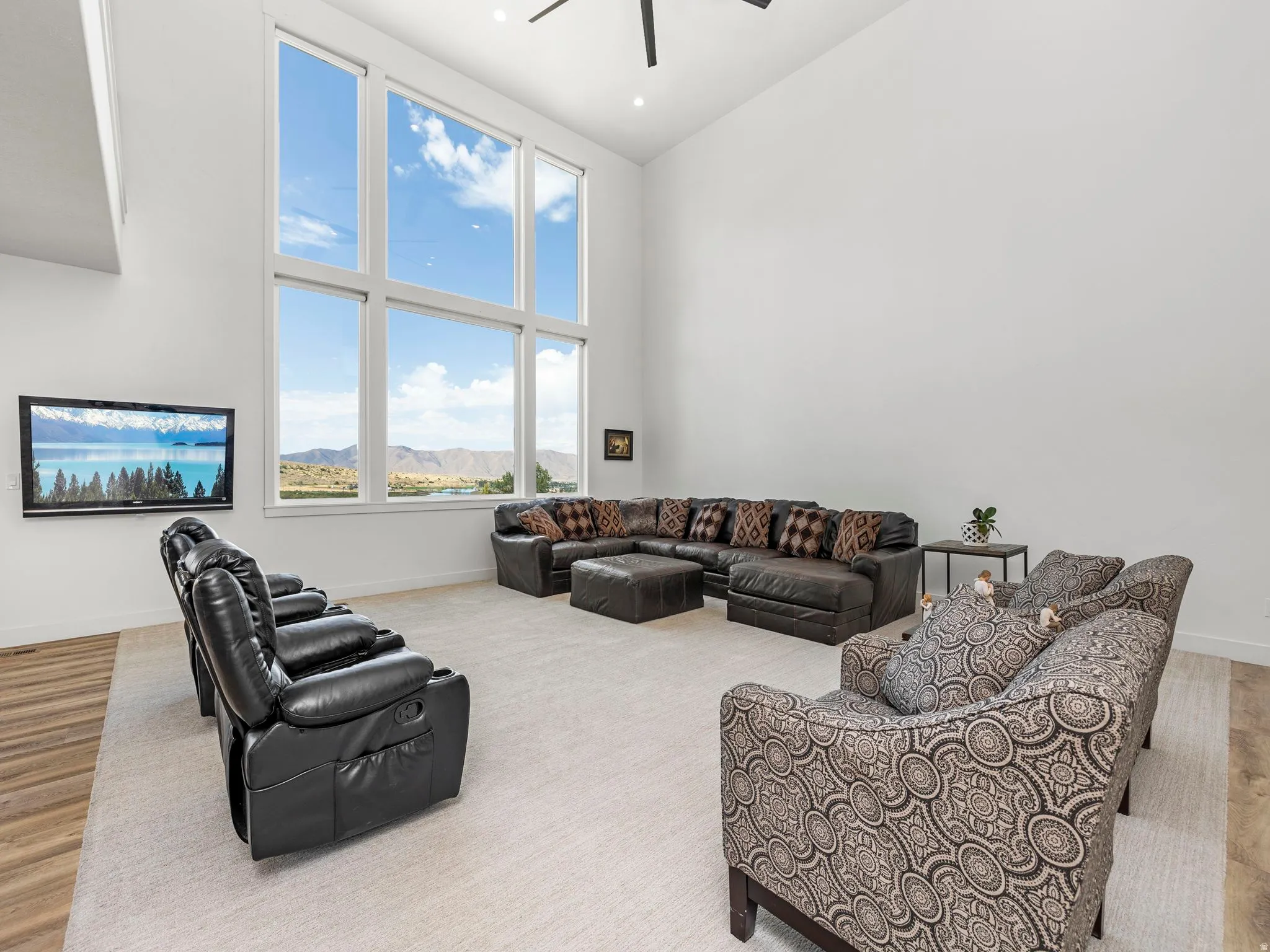 Living room with a high ceiling, ceiling fan, and recessed lighting