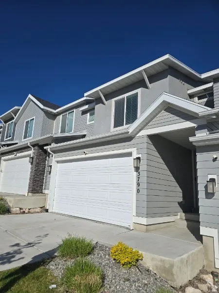 View of front facade featuring a garage and driveway