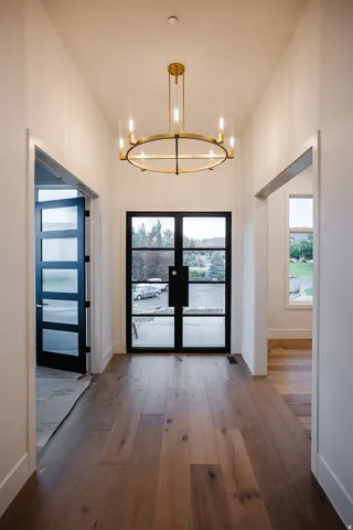 Entryway with french doors, hardwood / wood-style flooring, plenty of natural light, and a chandelier