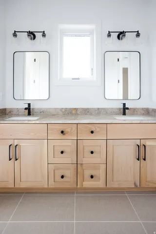 Bathroom featuring double vanity and tile patterned floors