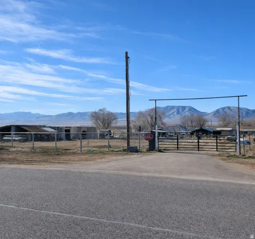 View of asphalt driveway with a mountain view, a gate, and a gated entry