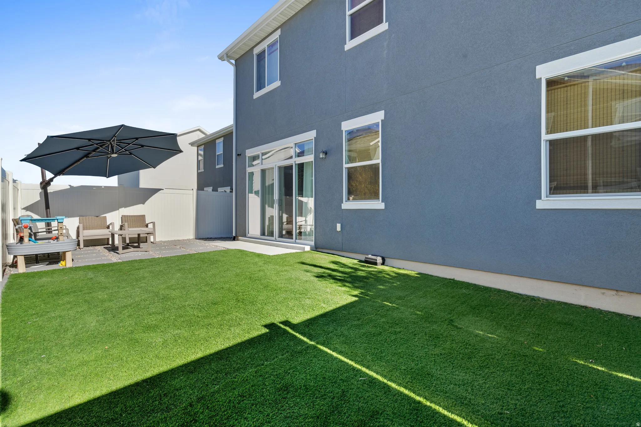 Rear view of house featuring stucco siding, a patio, and outdoor lounge area
