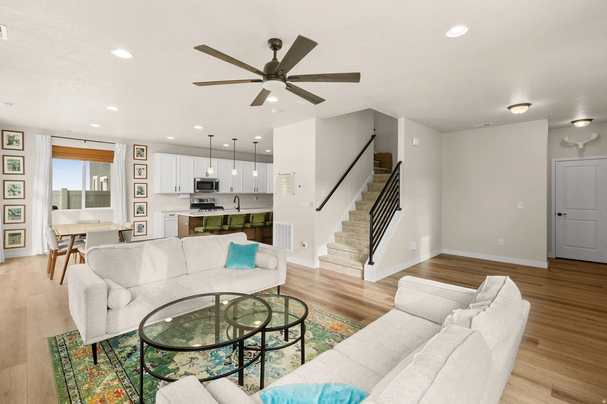 Living room with stairway, recessed lighting, light wood-type flooring, and ceiling fan