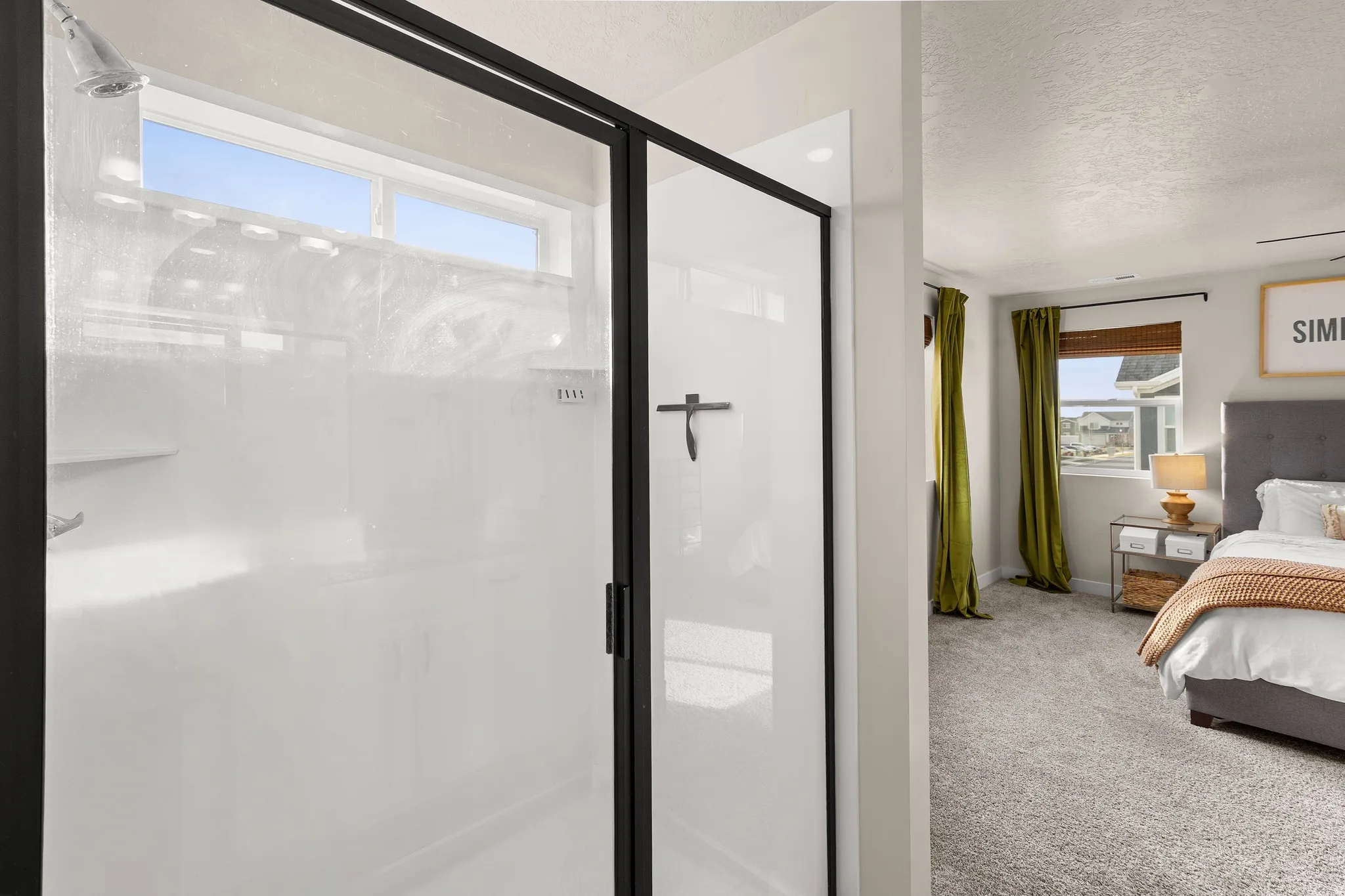 Ensuite bathroom featuring carpet floors, a shower stall, and a textured ceiling