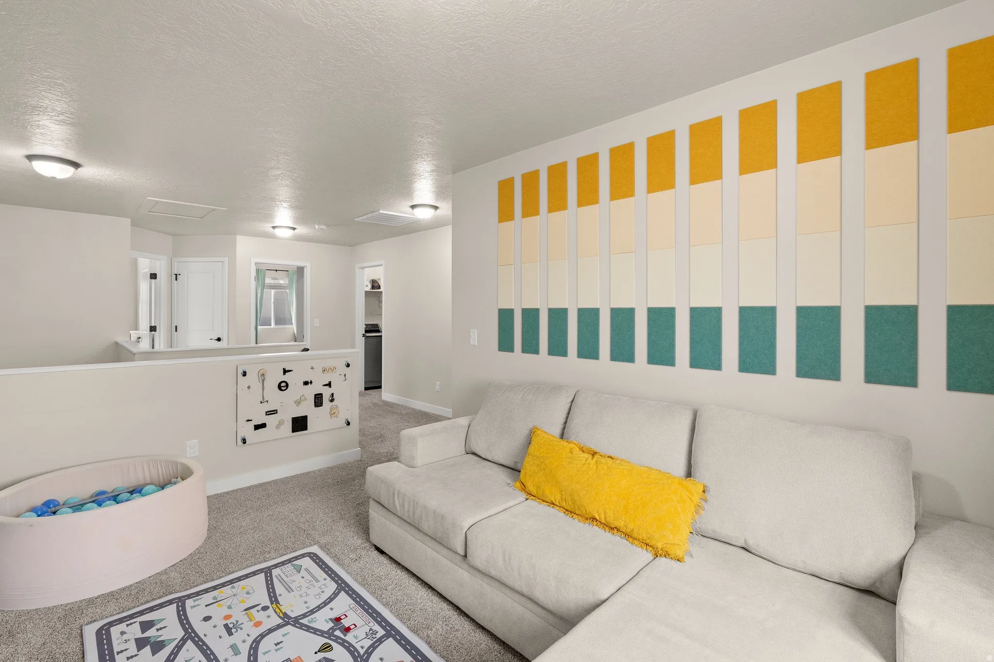 Living room featuring attic access, a textured ceiling, and carpet floors