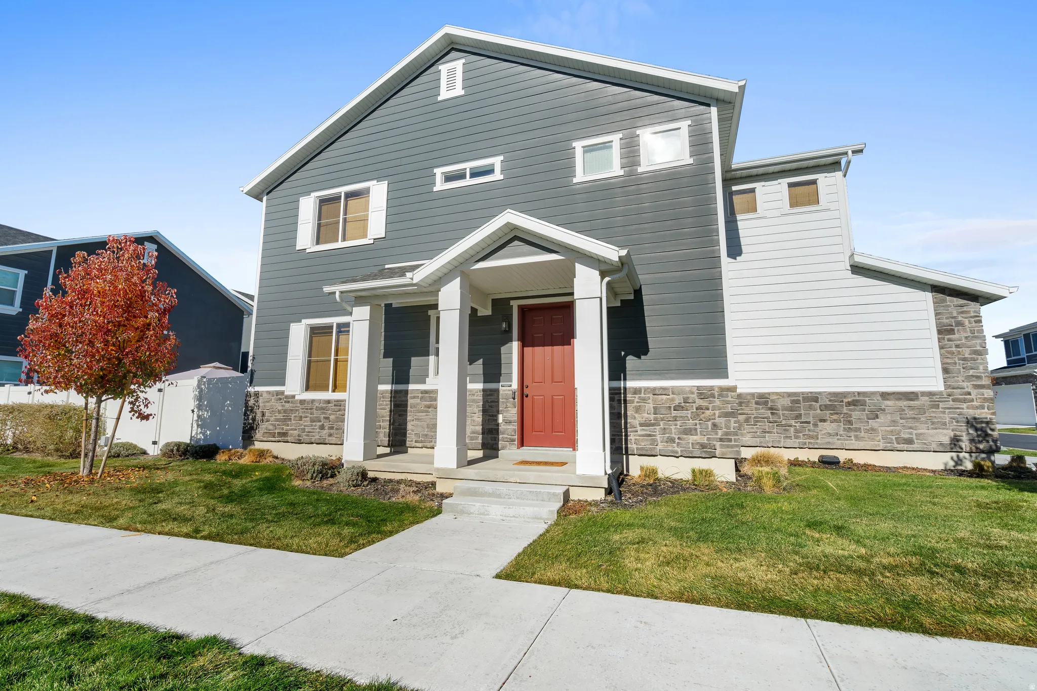 View of front facade featuring stone siding and a front yard