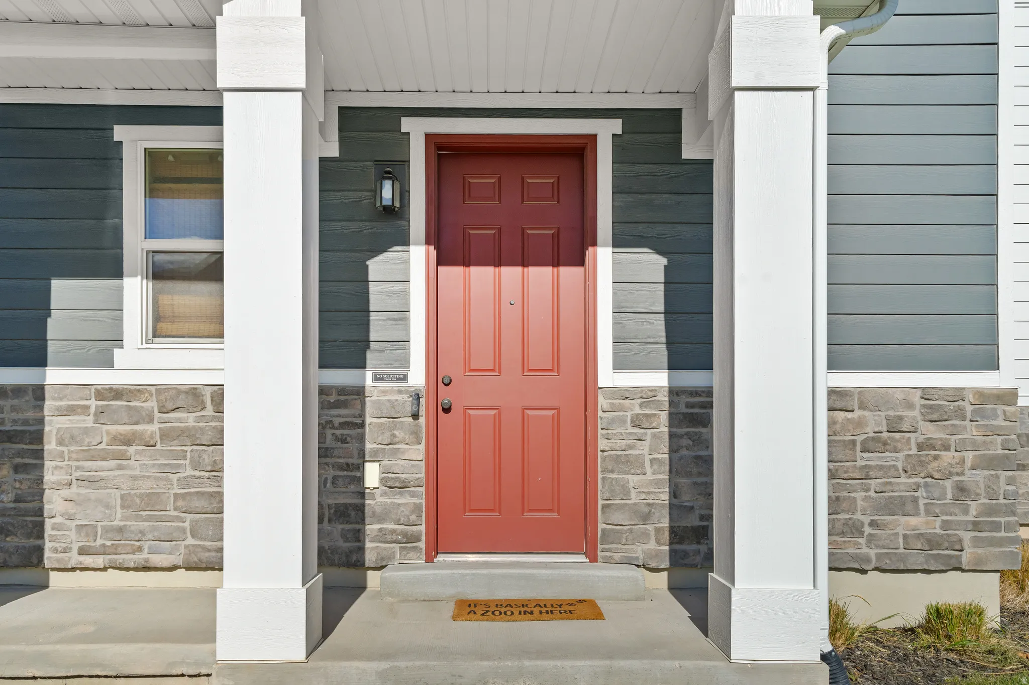Property entrance with stone siding and a porch