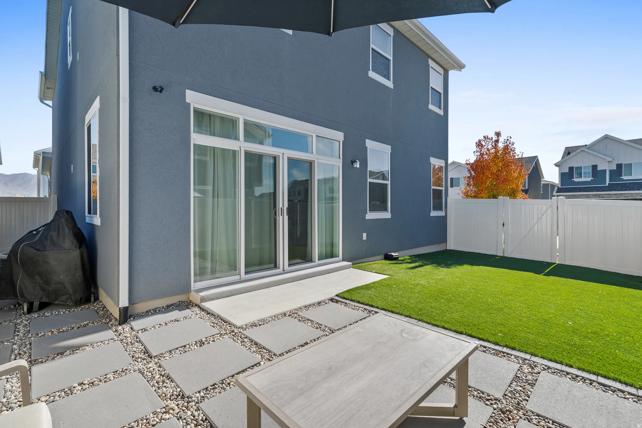 Rear view of property featuring a fenced backyard, a patio area, a gate, and stucco siding