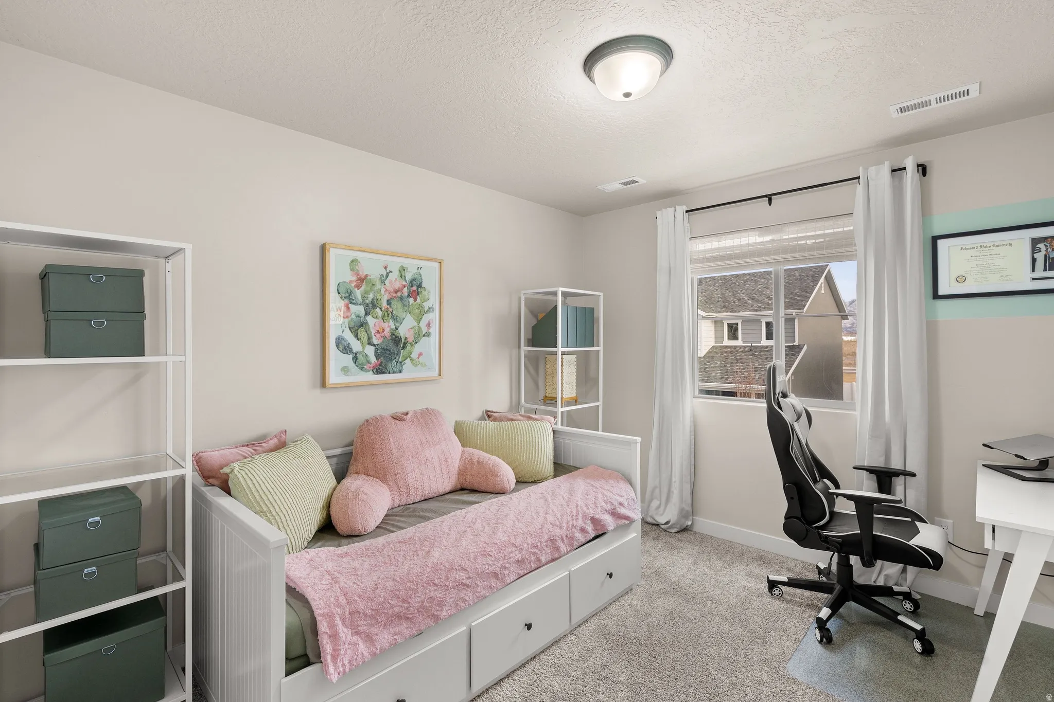 Bedroom with carpet, a textured ceiling, and a desk
