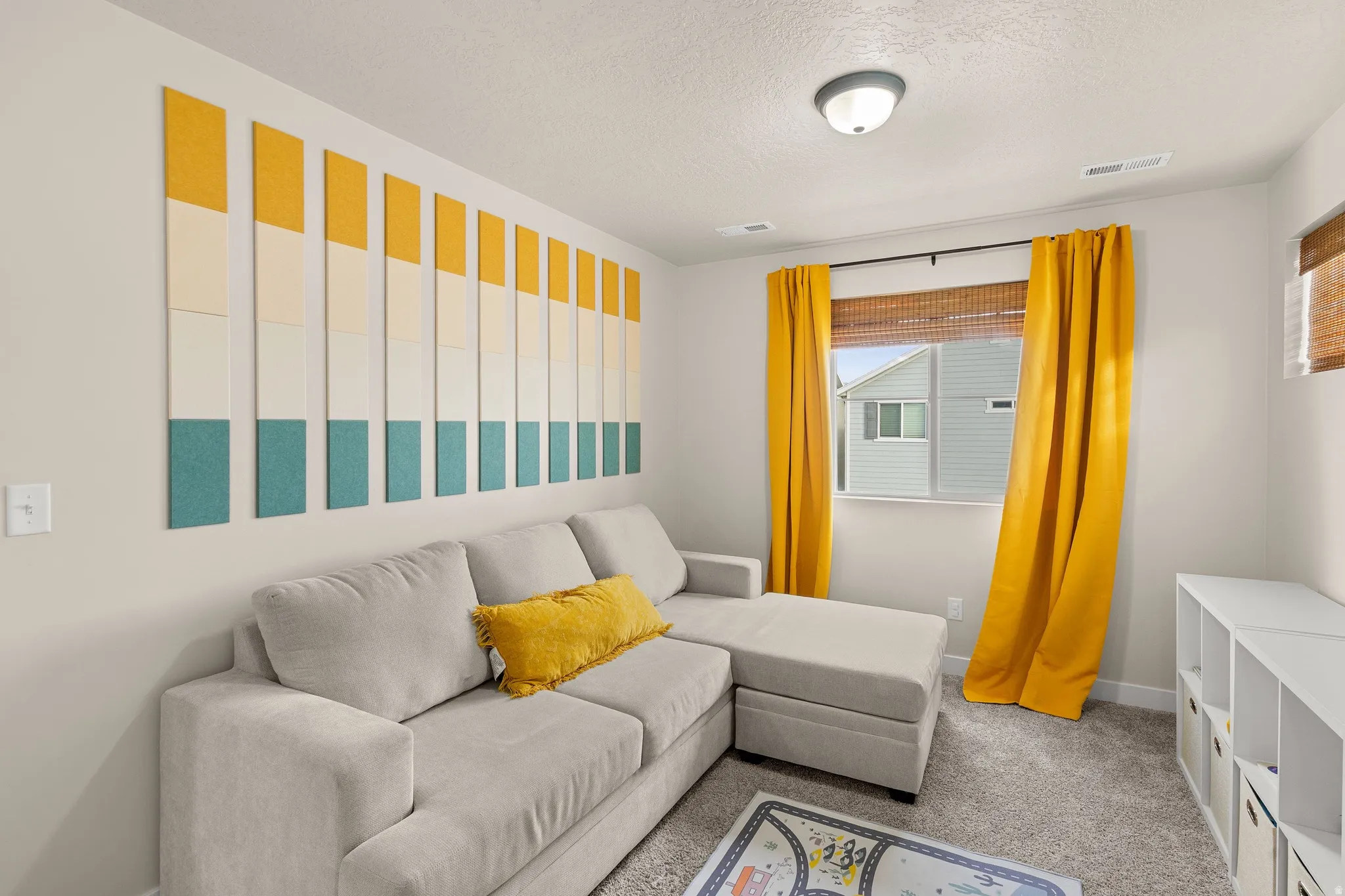 Carpeted living room featuring a textured ceiling and baseboards