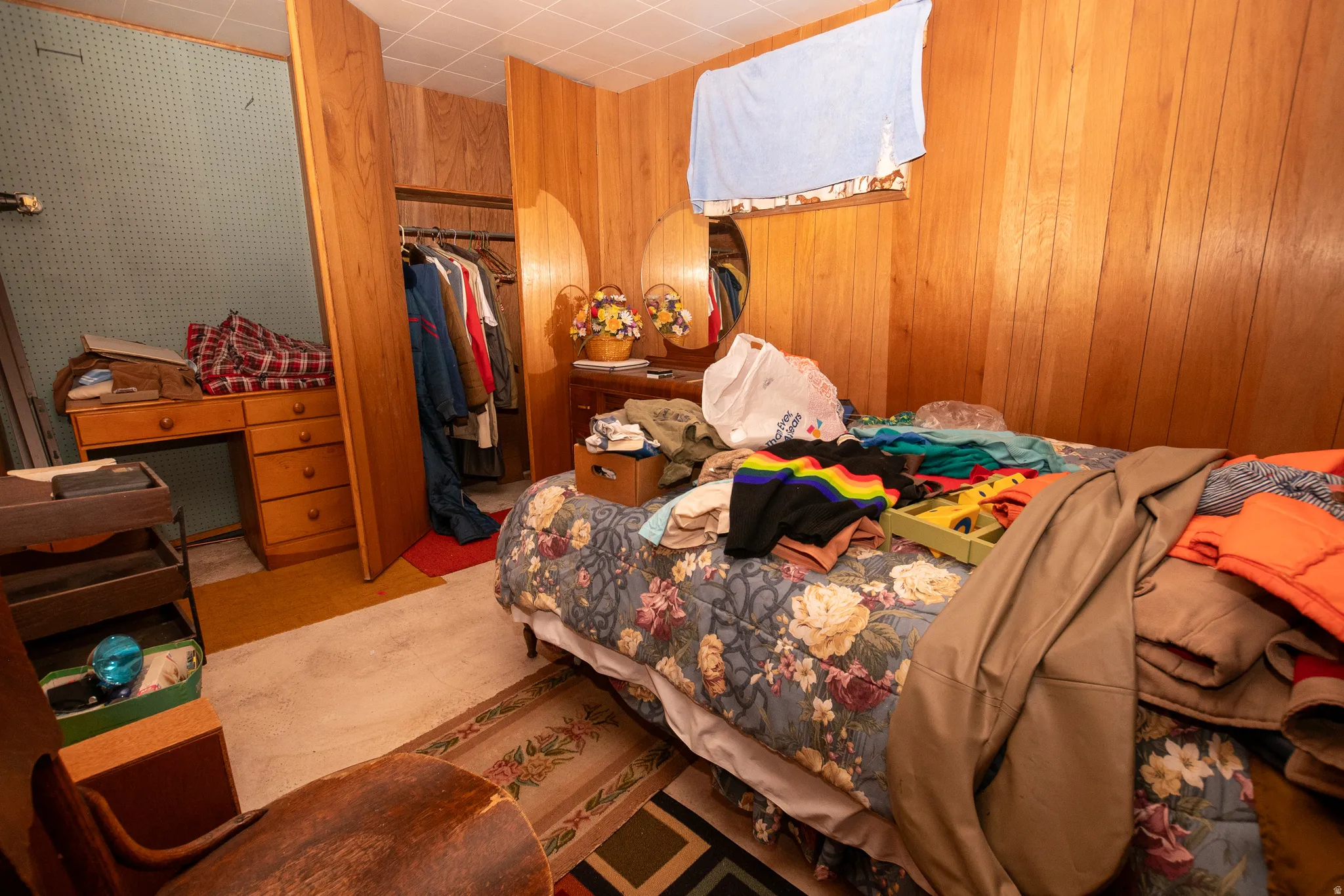 Bedroom featuring a closet and wood walls