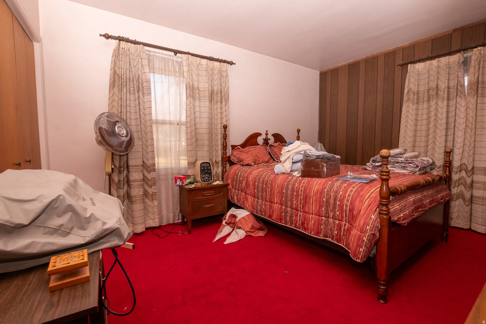 Bedroom with wood walls, carpet flooring, a closet, and an accent wall