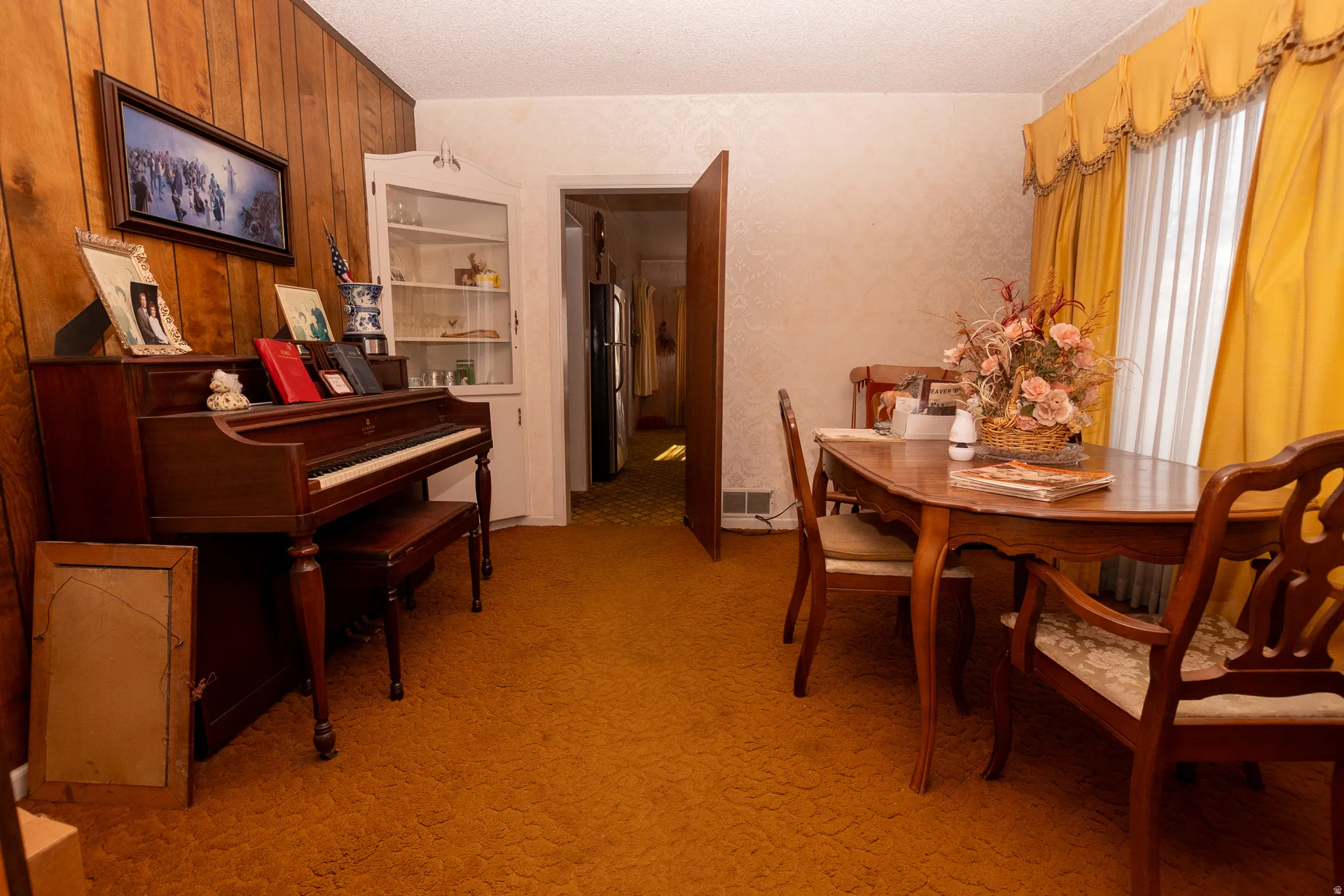 Dining space featuring light colored carpet and a textured ceiling