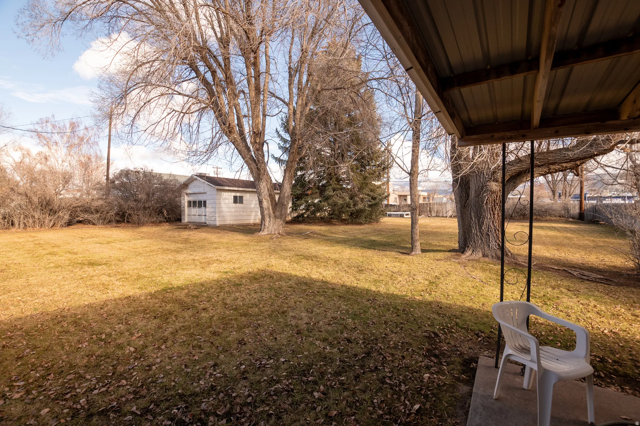 View of green lawn featuring an outbuilding