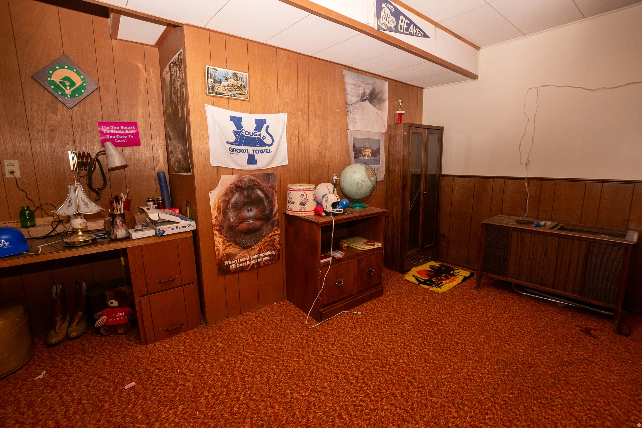 Carpeted home office featuring wood walls and a wainscoted wall