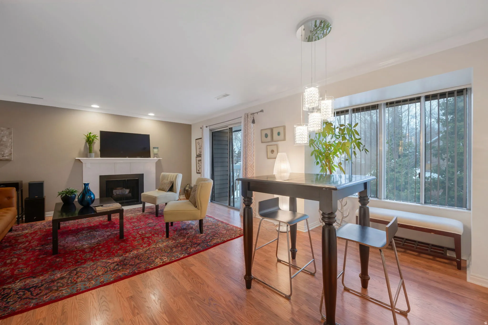 Dining room with a fireplace, wood finished floors, and crown molding