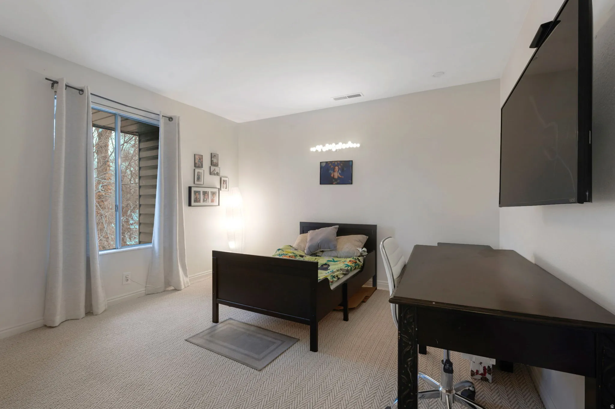 Bedroom featuring light carpet and baseboards