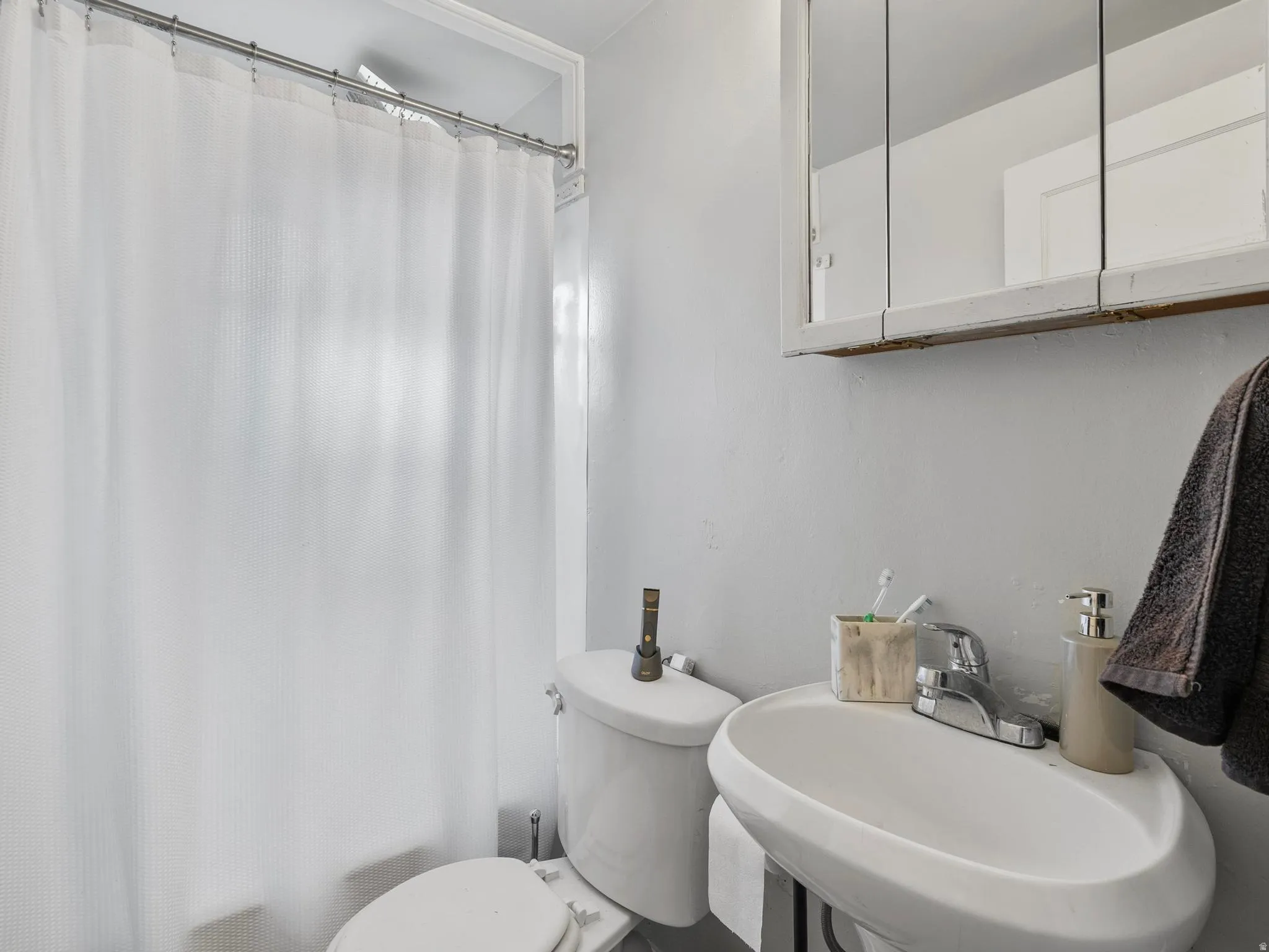 Full bathroom featuring toilet and shower / tub combo with curtain