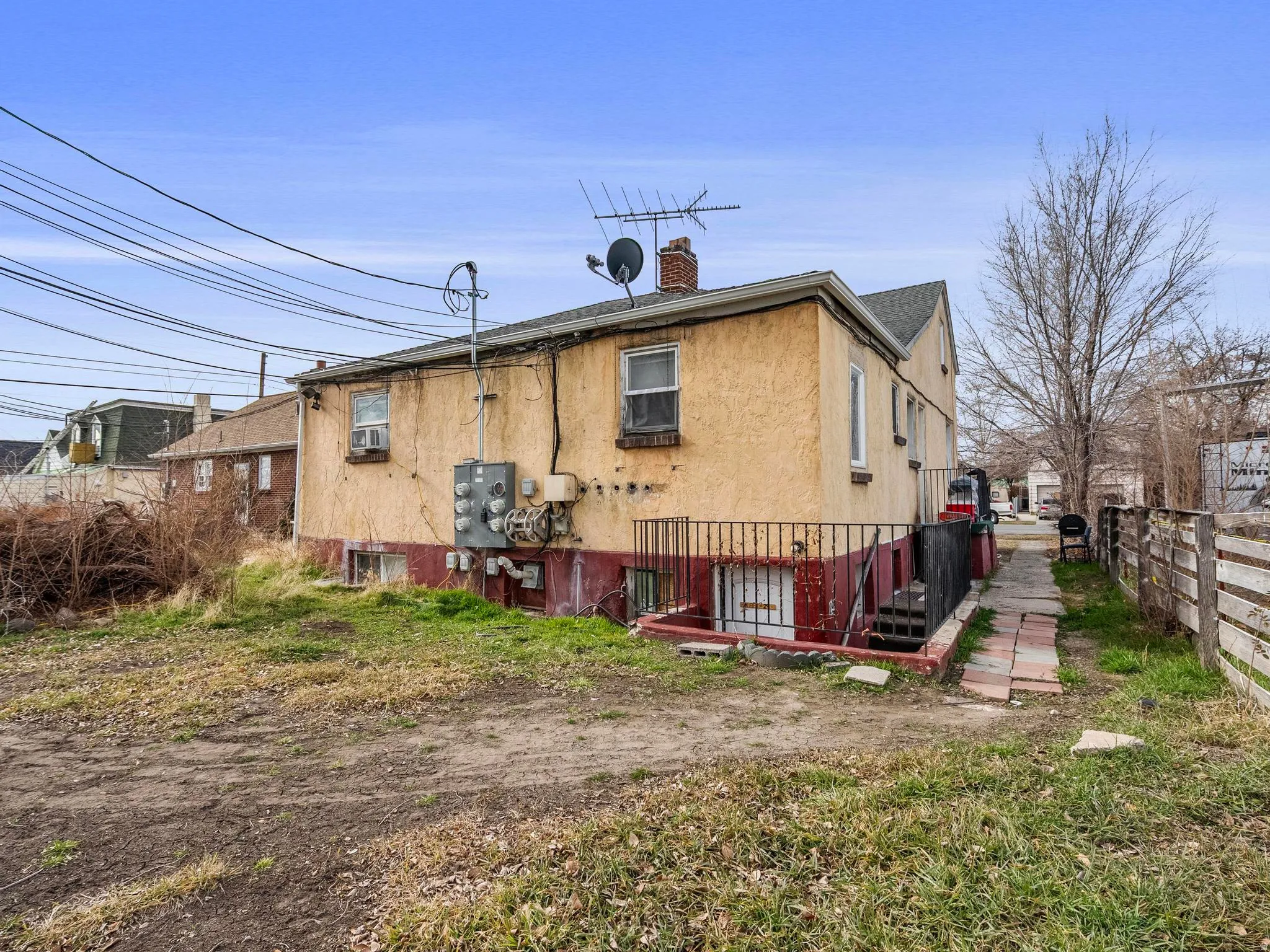 Rear of the property with basement entrance to shared laundry room and studio apartment