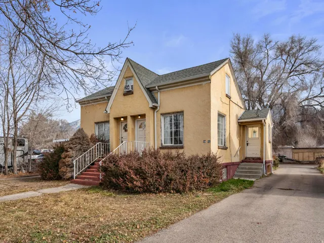 View of front of 4-Plex with stucco siding and asphalt shingles; showing the rear entrance to the 2 bedroom unit