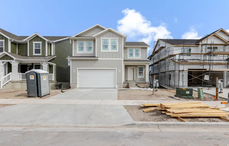 View of front of home with board and batten siding, a garage, driveway, and covered porch