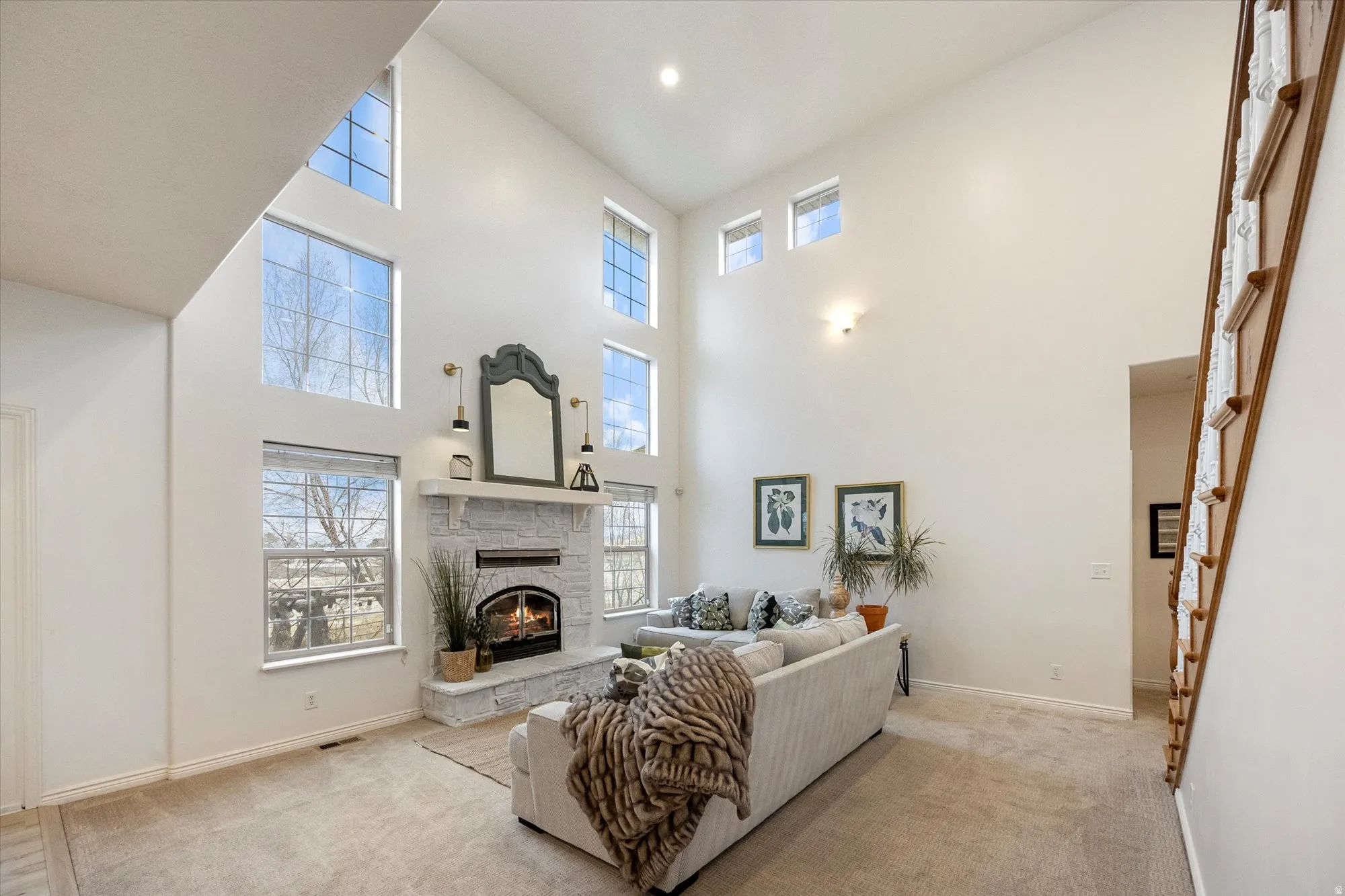 Carpeted living area featuring a fireplace and a high ceiling