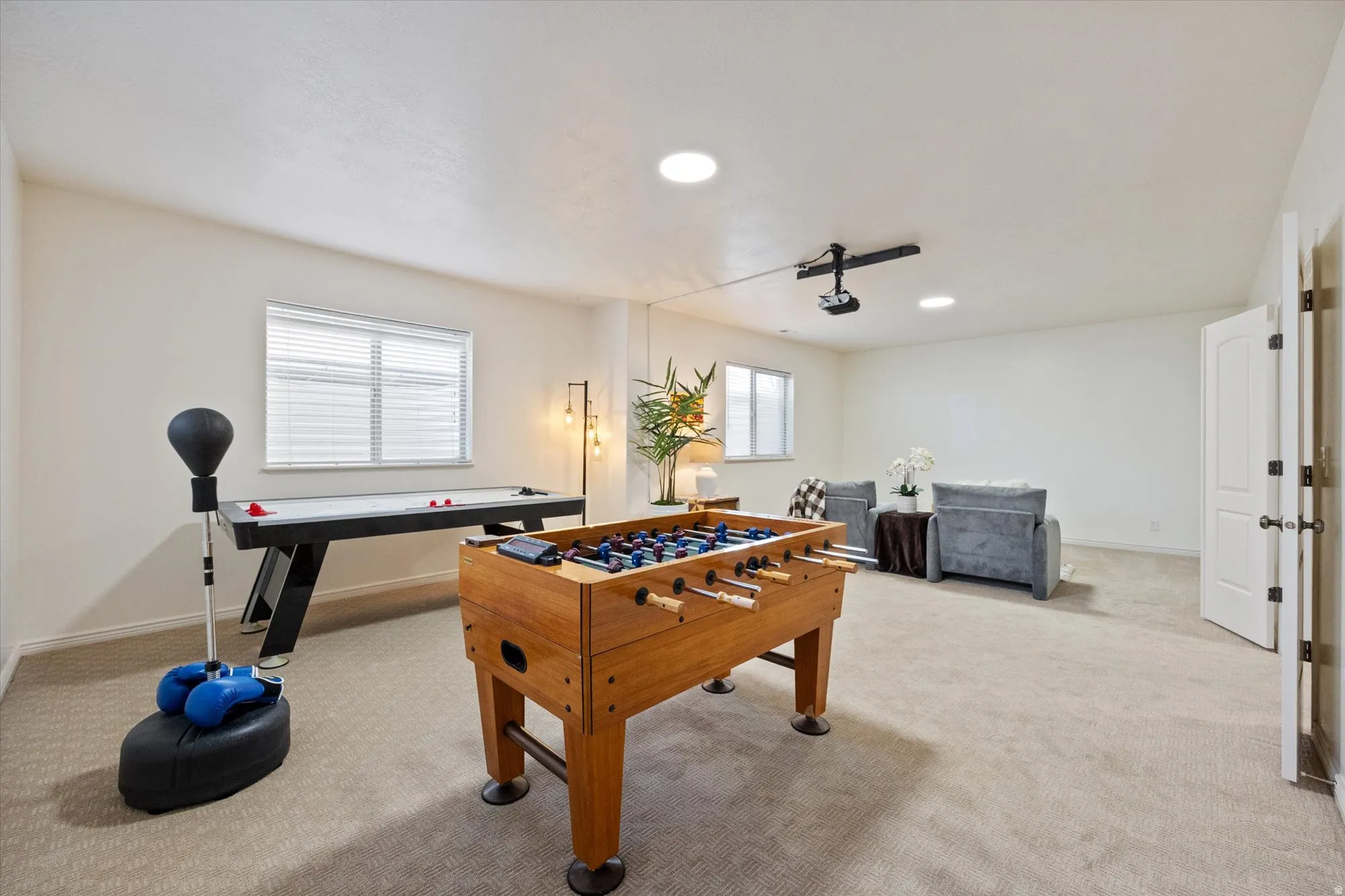 Game room with light colored carpet and recessed lighting