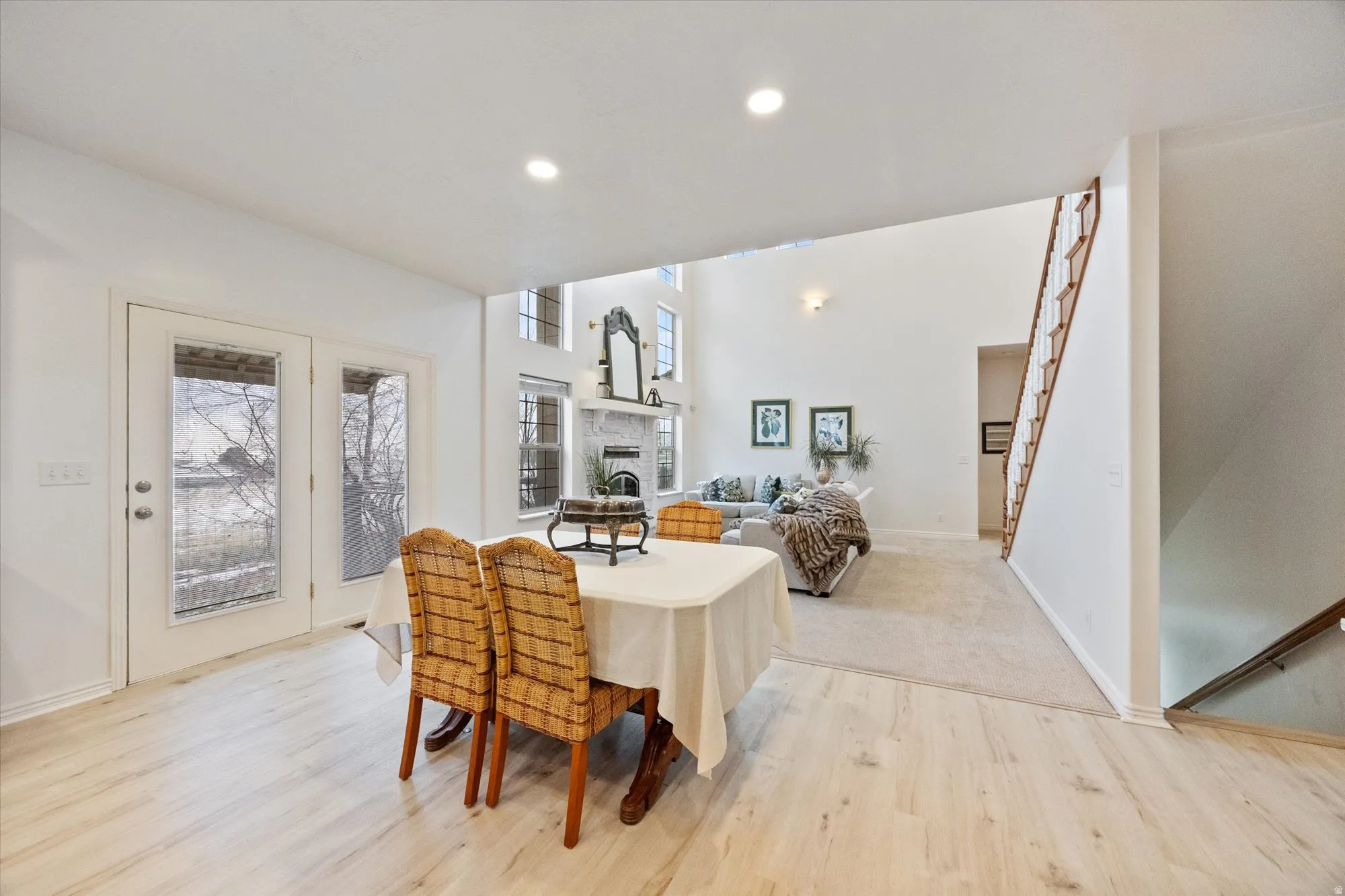 Dining area with a fireplace, healthy amount of natural light, recessed lighting, light wood-style flooring, and stairs