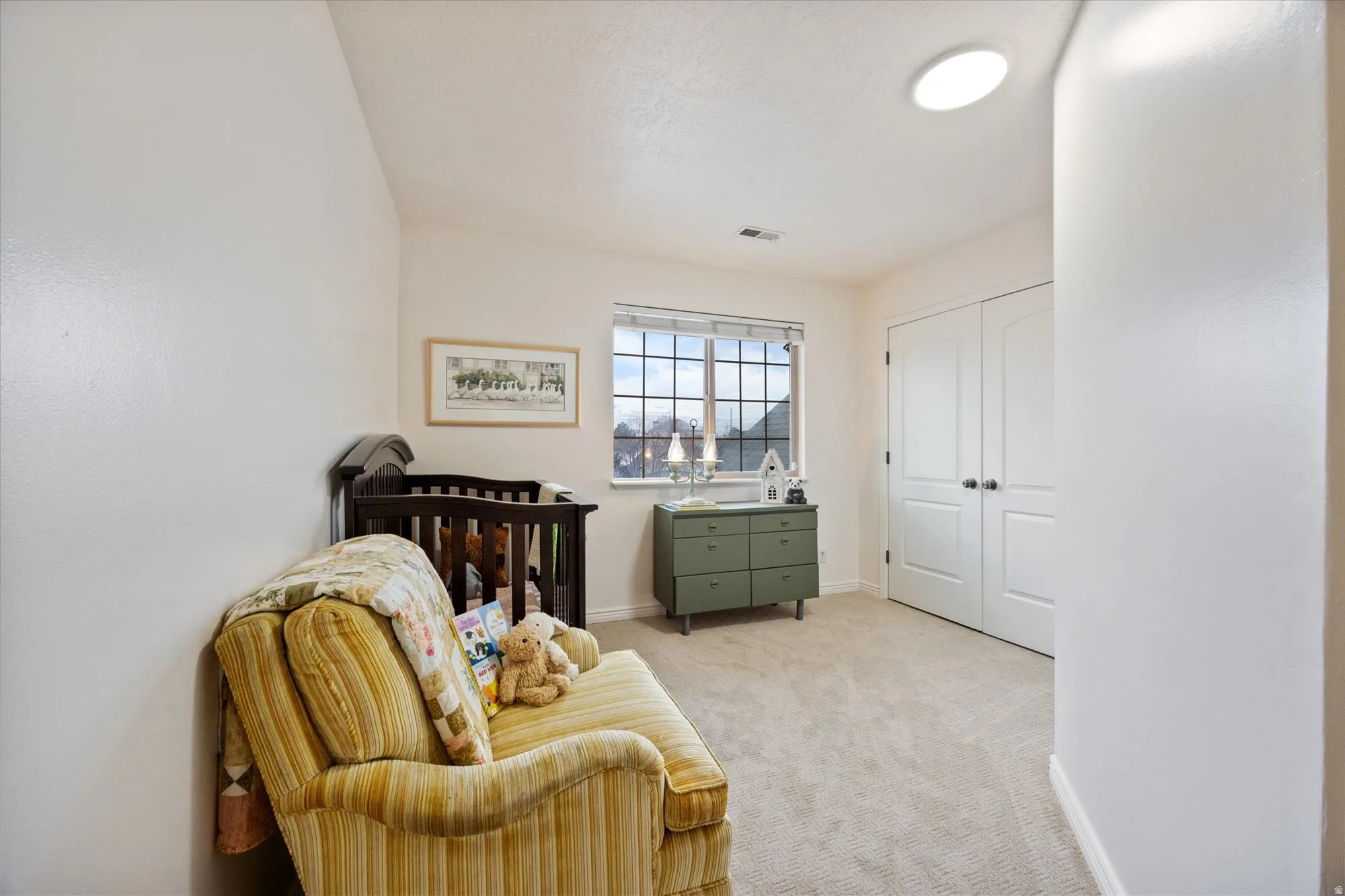 Sitting room with light colored carpet and baseboards