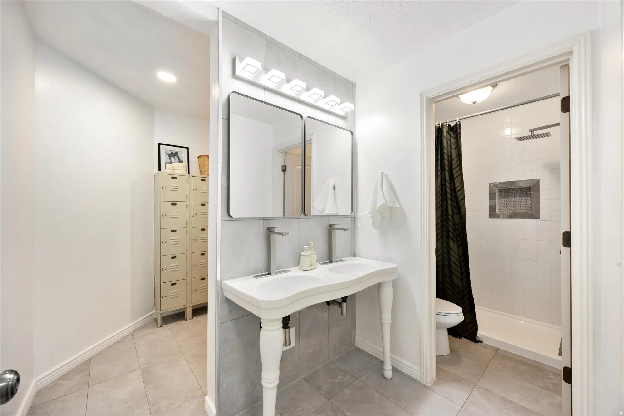 Bathroom featuring a shower stall and light tile patterned floors