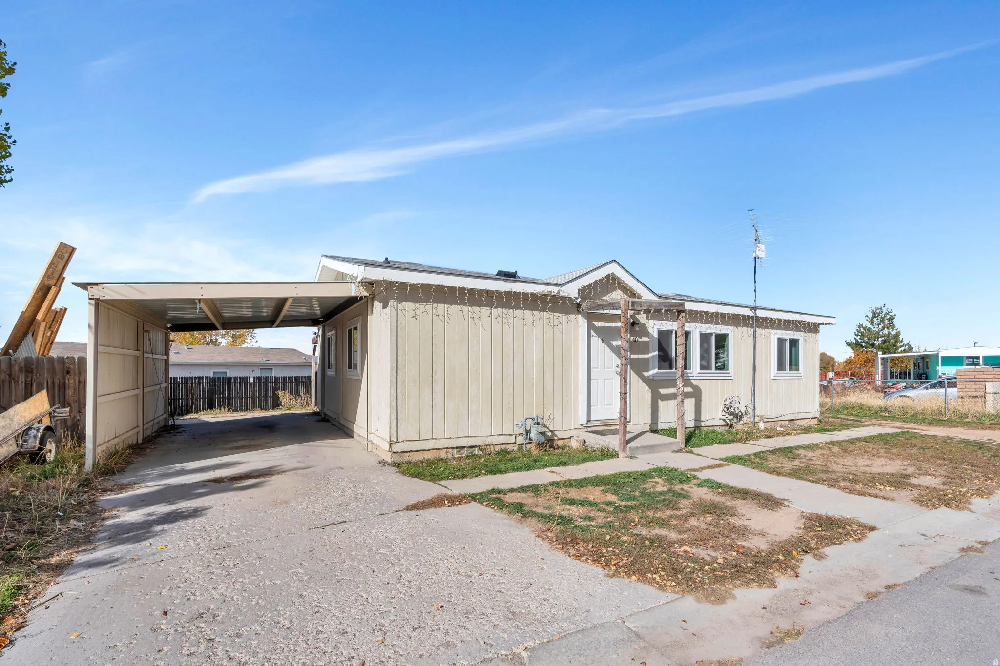Manufactured / mobile home featuring an attached carport and concrete driveway