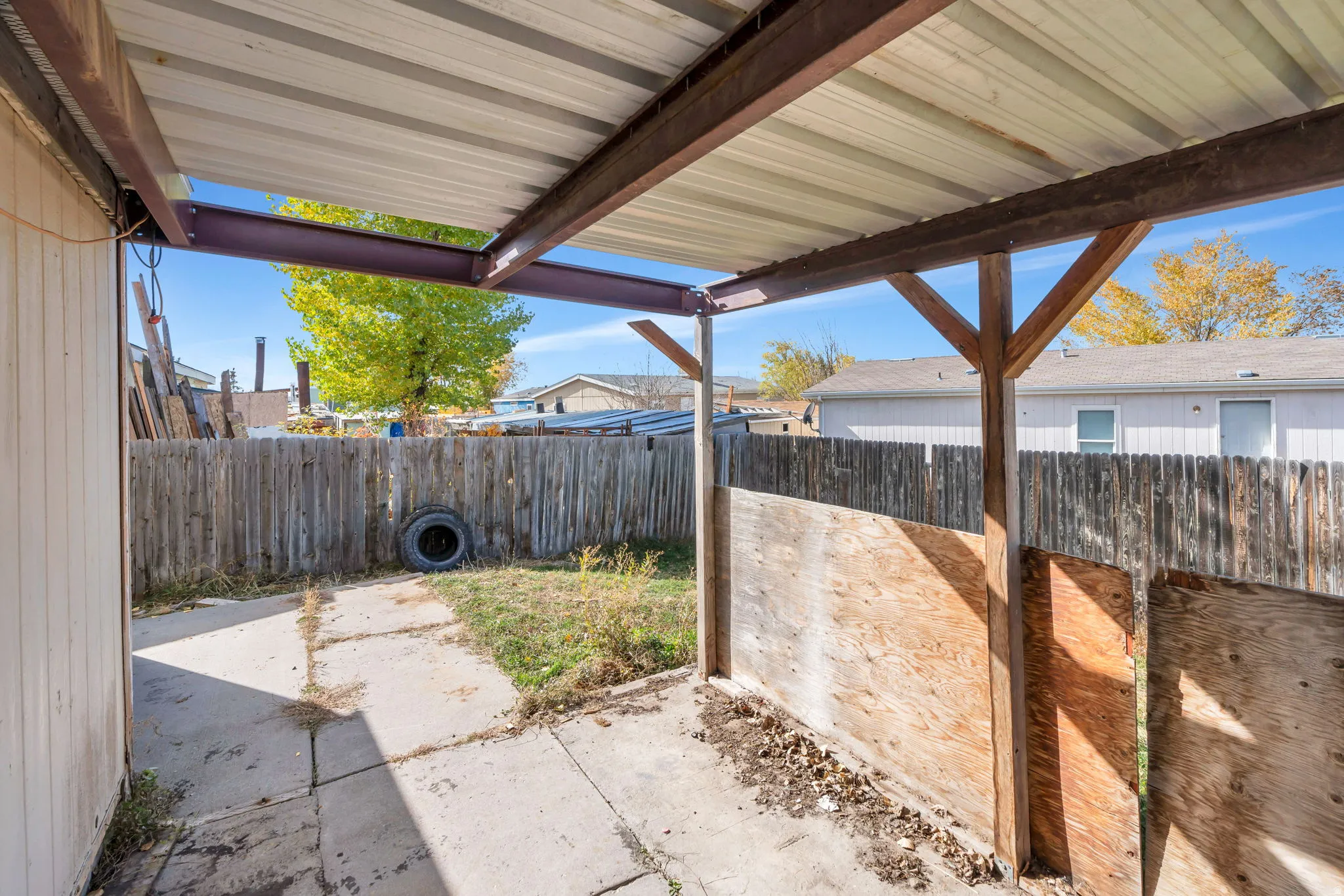 Fenced backyard with a covered patio area
