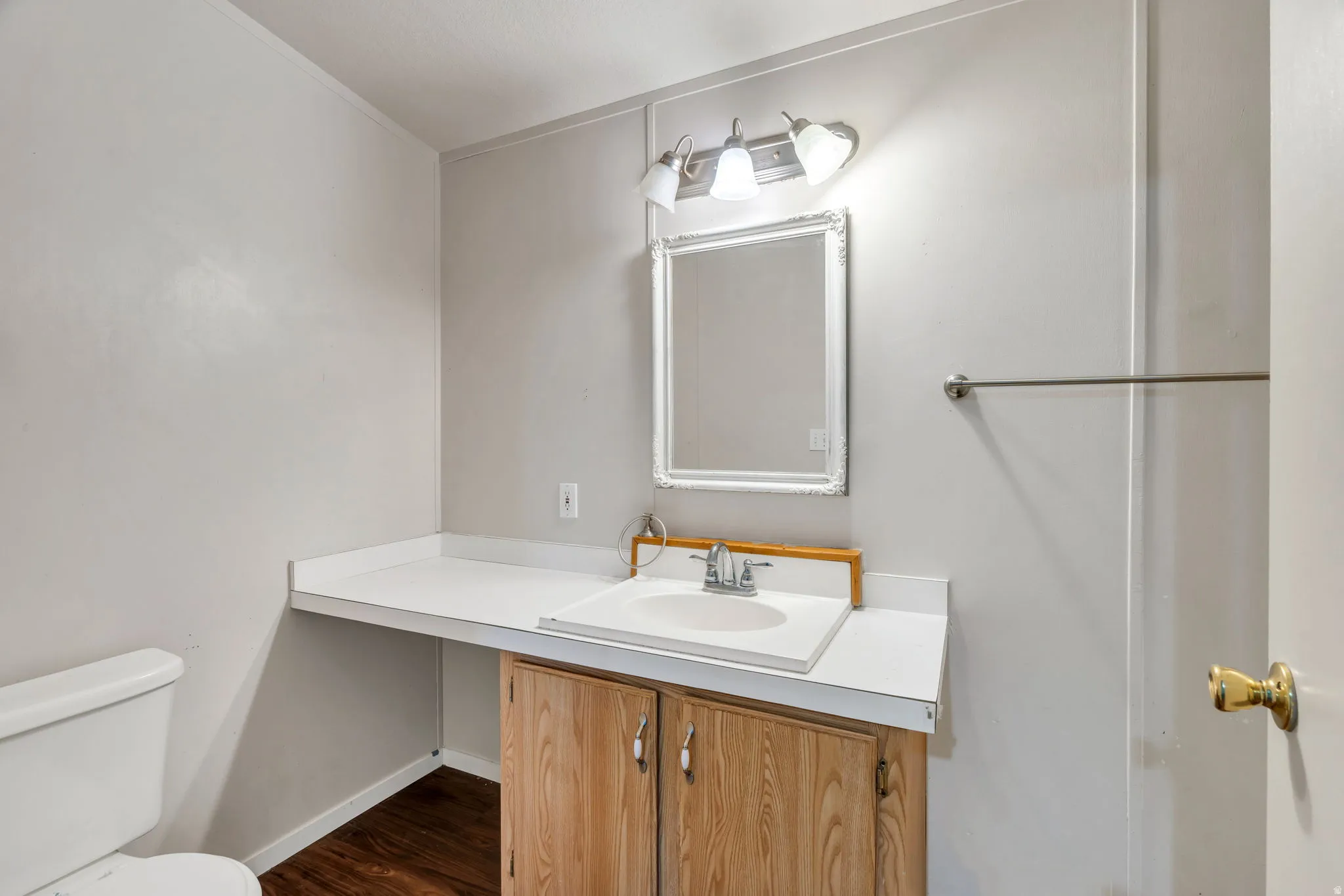 Half bath featuring vanity and dark wood finished floors
