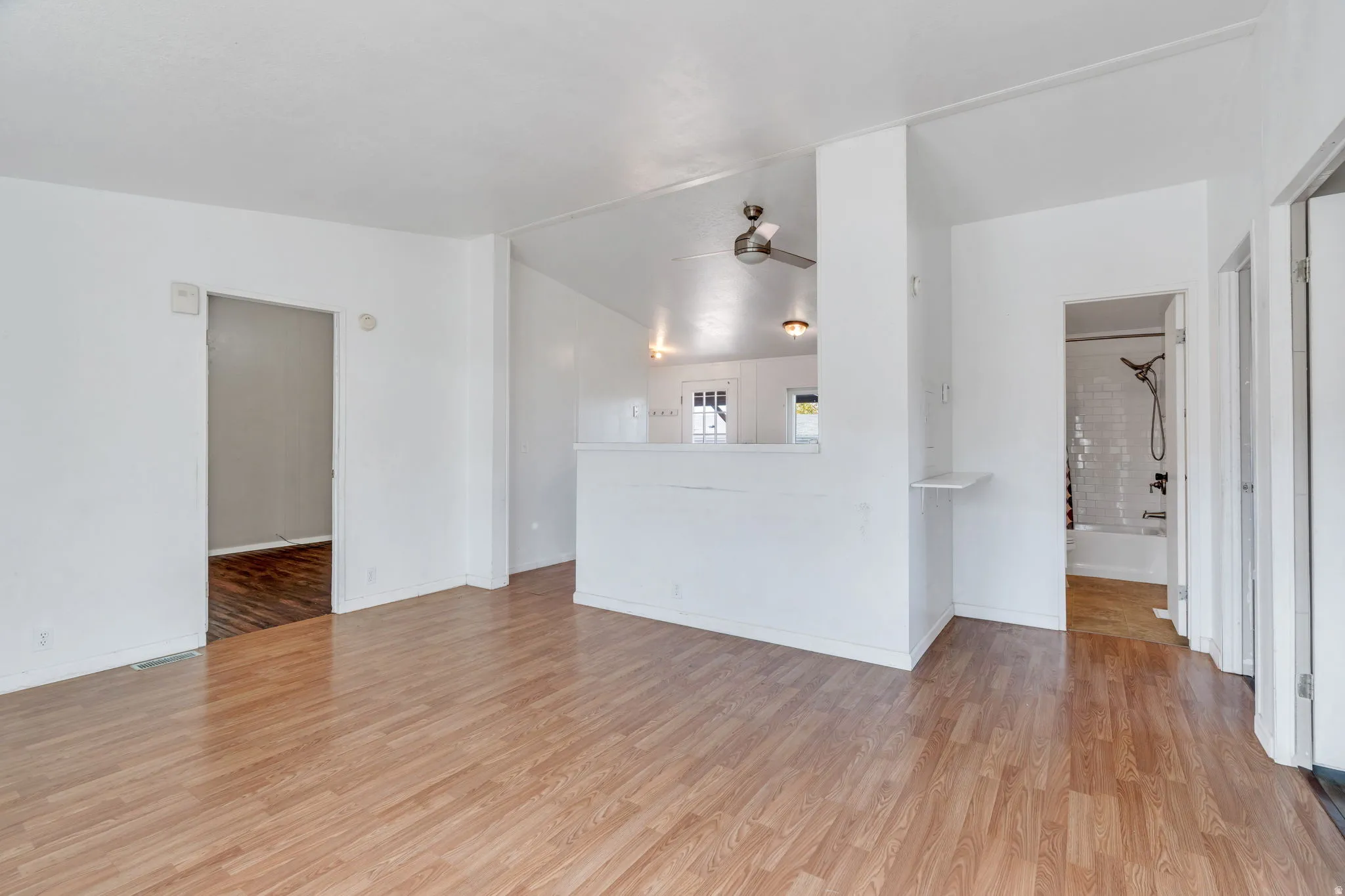 Unfurnished living room featuring ceiling fan and light wood-style flooring