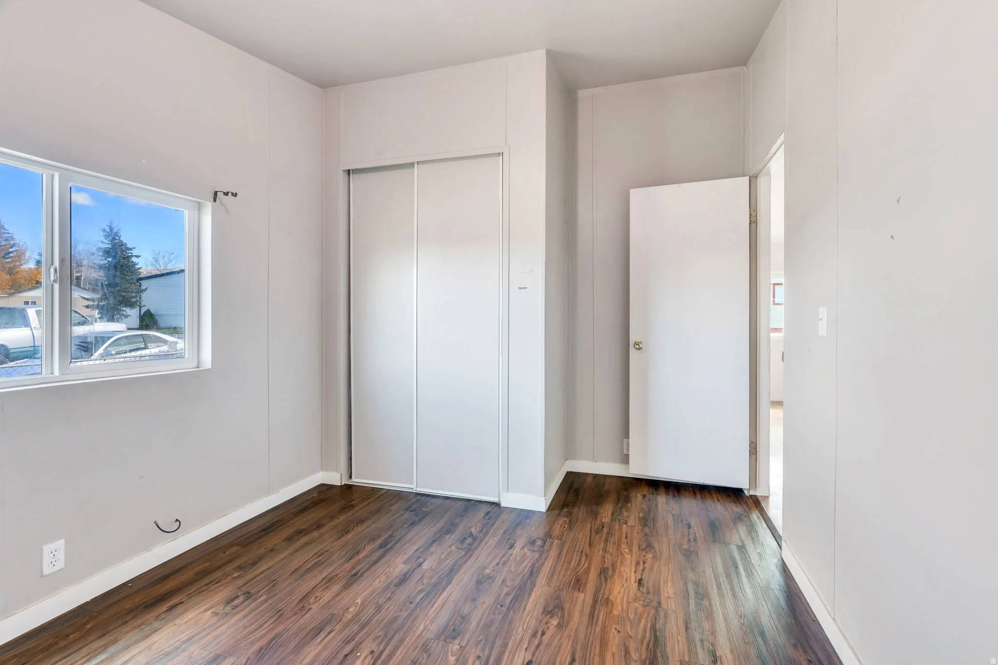 Unfurnished bedroom featuring dark wood-type flooring and a closet