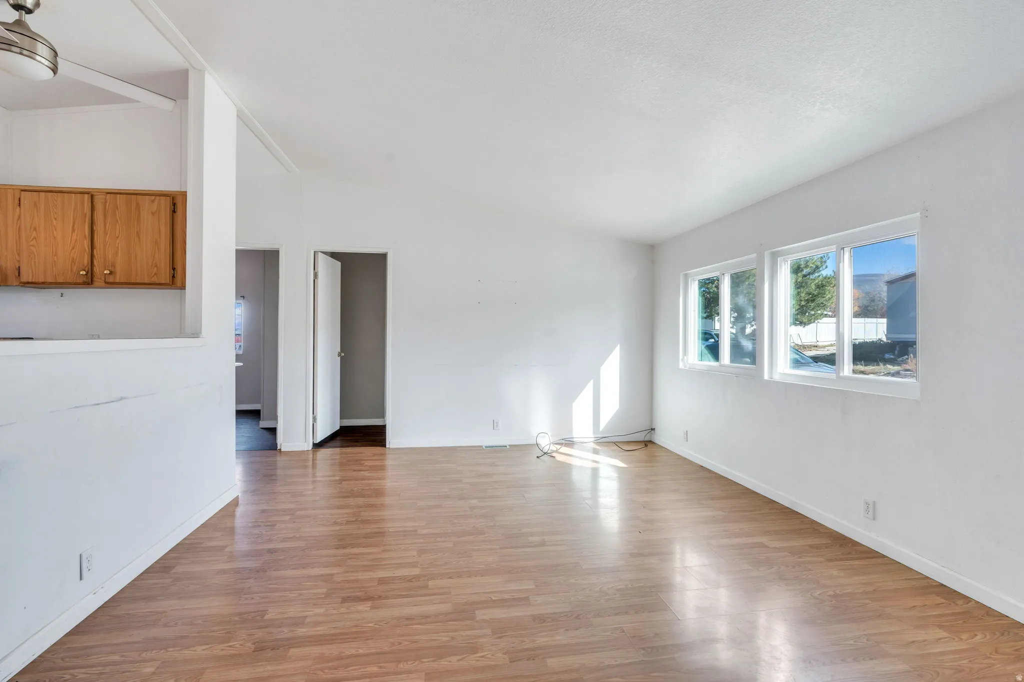 Unfurnished living room featuring vaulted ceiling and light wood-style floors