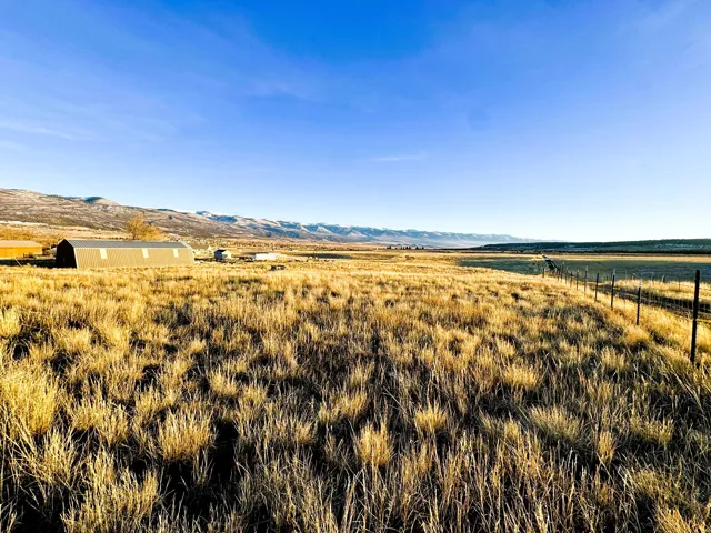 View of yard with a view of rural / pastoral area, a mountain view, an outdoor structure, and a pole building