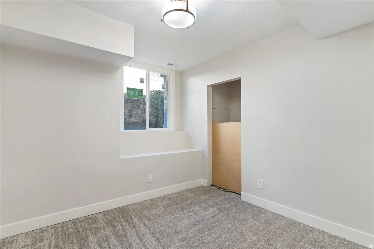 Carpeted spare room featuring baseboards
