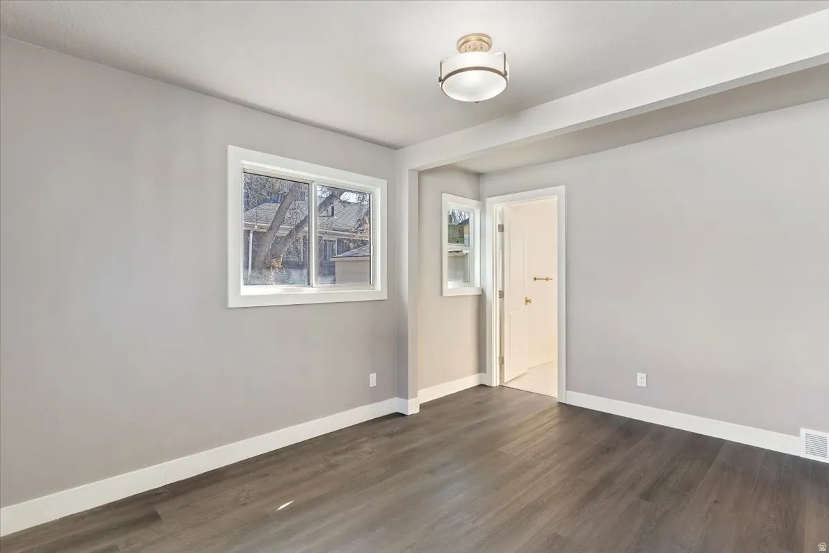 Empty room with baseboards and dark wood finished floors
