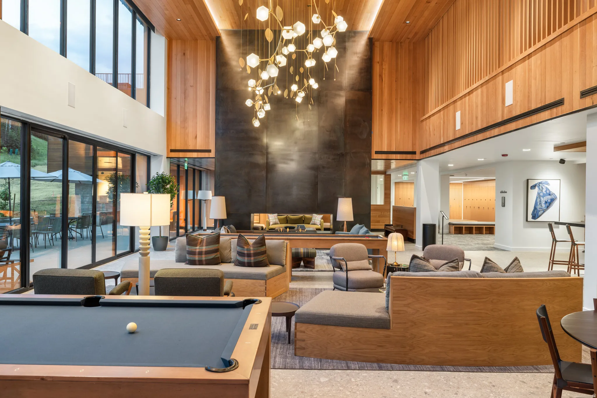 Building lobby with a towering ceiling, wooden walls, and recessed lighting